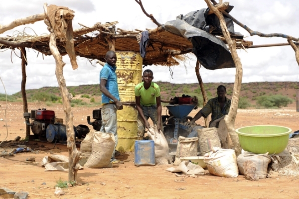 Children working under a wooden tent on the terrain of an illegal gold mine.